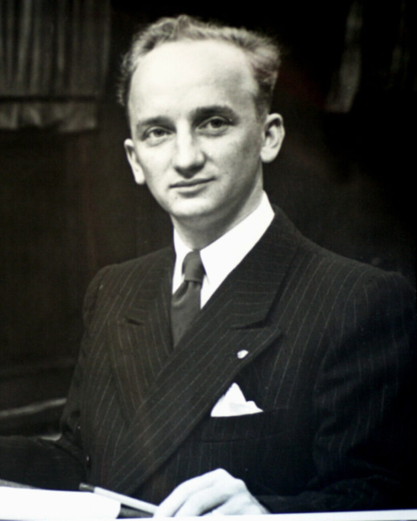 Nuori, pukuun pukeutunut mies.